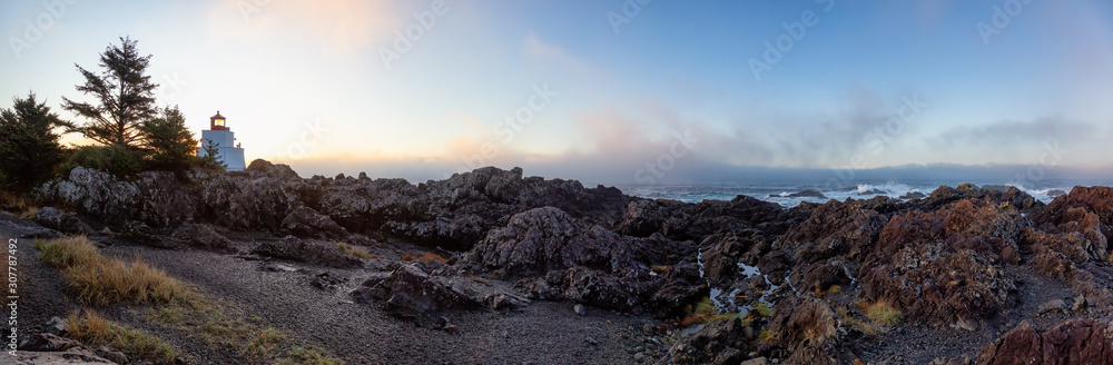 Beautiful Panoramic View of the Rocky Pacific Ocean Coast during a colorful cloudy sunrise with lighthouse in background. Taken on Wild Pacific Trail in Ucluelet, Vancouver Island, BC, Canada.
