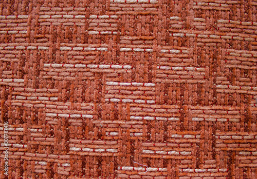 The texture of red fabric with large weaving.  Upholstery of furniture.