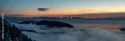 St Mark's Summit, in Howe Sound, North of Vancouver, British Columbia, Canada. Panoramic Canadian Mountain Landscape View from the Peak during cloudy winter sunset.