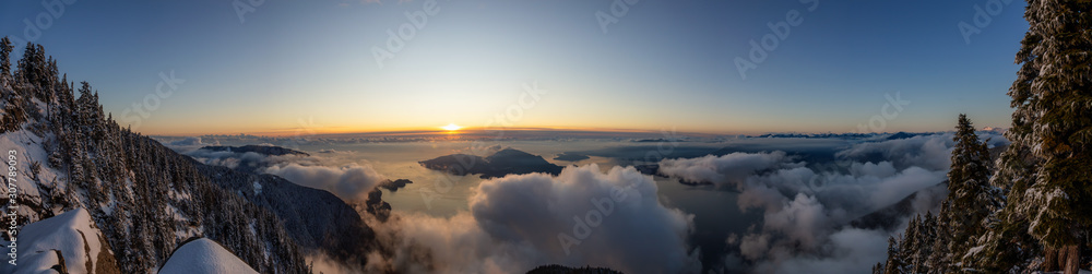 Fototapeta premium St Mark's Summit, in Howe Sound, North of Vancouver, British Columbia, Canada. Panoramic Canadian Mountain Landscape View from the Peak during cloudy winter sunset.