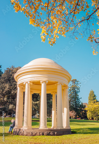 A man set down at the temple of the winds in Fitzroy gardens.	