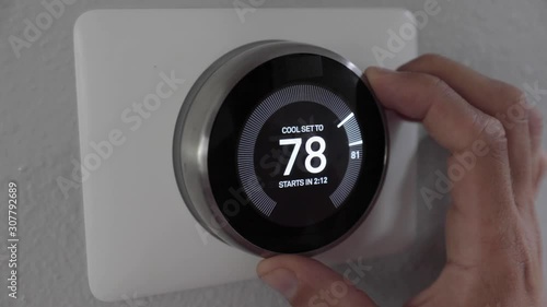Man Adjusting Smart Thermostat Gadget At Home