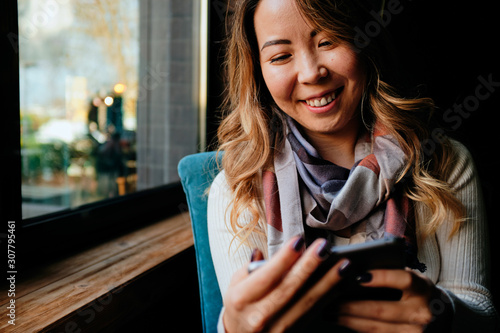 Beautiful Asian woman with tablet in her hands smiling