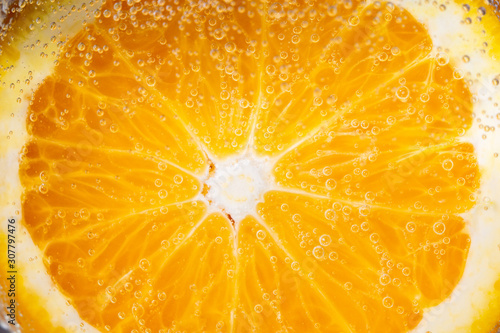 Ripe juicy orange half cut closeup, macro, background, fresh fruit under water, bubbles