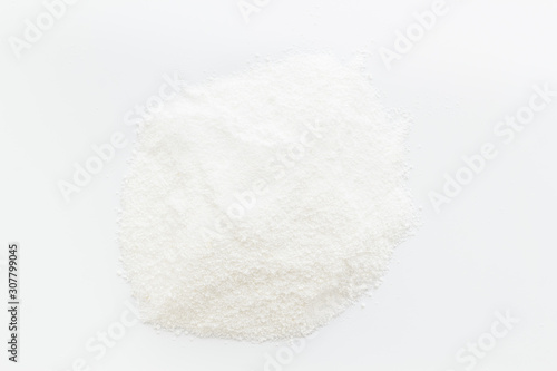 Washing powder scattered on white background top view
