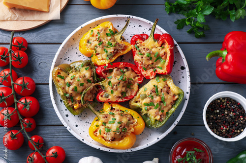 Flat lay composition with tasty stuffed bell peppers on grey wooden table