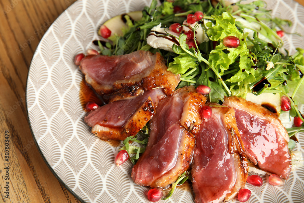 Delicious salad with roasted duck breast served on wooden table, closeup Delicious salad with roasted duck breast served on wooden table, closeup