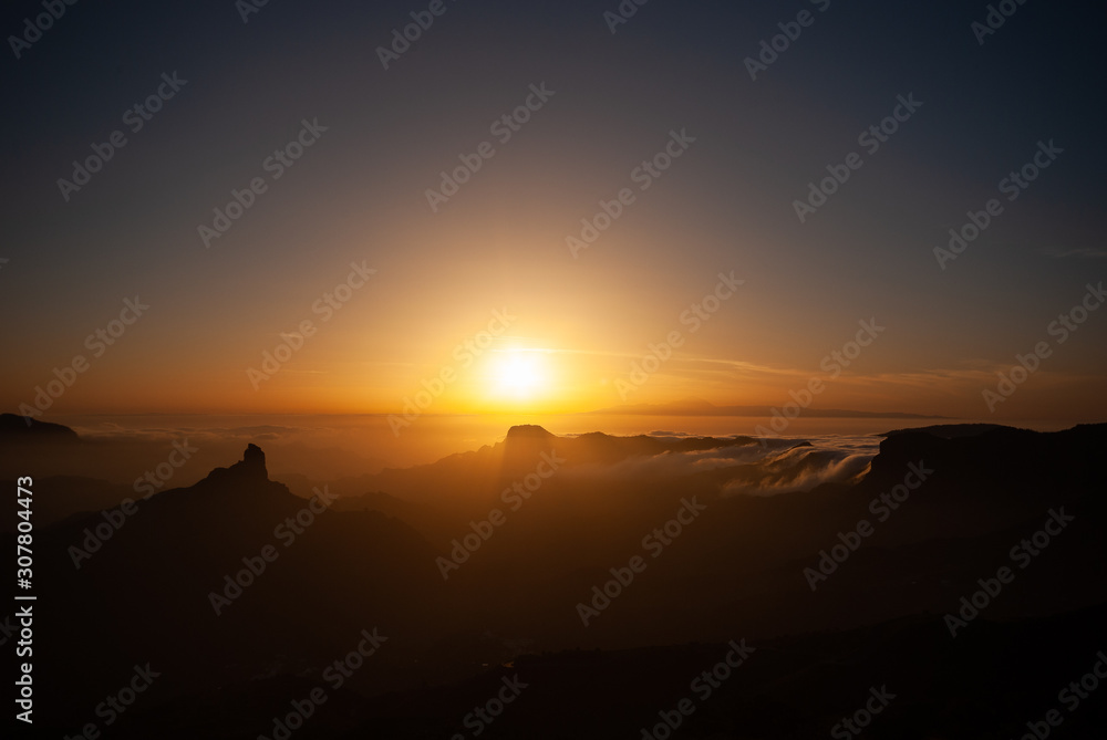 Sceninc overview over Gran Canaria facing Tenerife with the Teide from the mountain peak Pico de las Nieves during sunset