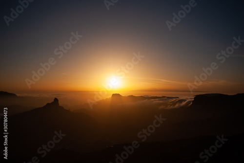 Sceninc overview over Gran Canaria facing Tenerife with the Teide from the mountain peak Pico de las Nieves during sunset