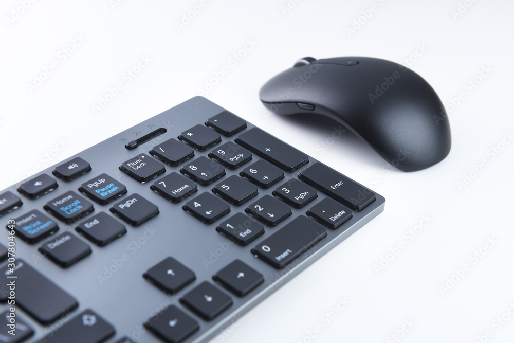Wireless gray keyboard and mouse on a white background close-up. Wireless gray keyboard and mouse on a white background close-up.