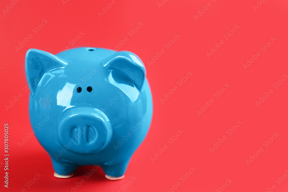Blue piggy bank on red background. Space for text