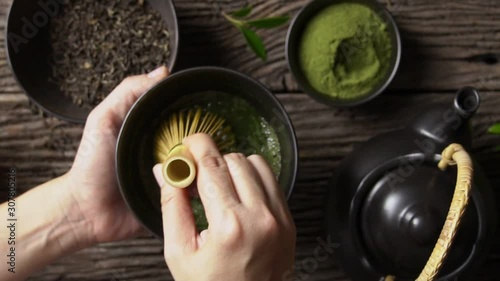 Preparing Japanese organic matcha green tea powder in the black bowl with wire whisk on wooden table, Organic product from the nature for healthy with traditional style