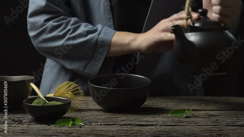 Preparing Japanese organic matcha green tea powder in the black bowl with wire whisk on wooden table, Organic product from the nature for healthy with traditional style