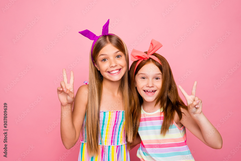 Portrait of charming kids making v-signs wearing bright dress skirt isolated over pink background Portrait of charming kids making v-signs wearing bright dress skirt isolated over pink background