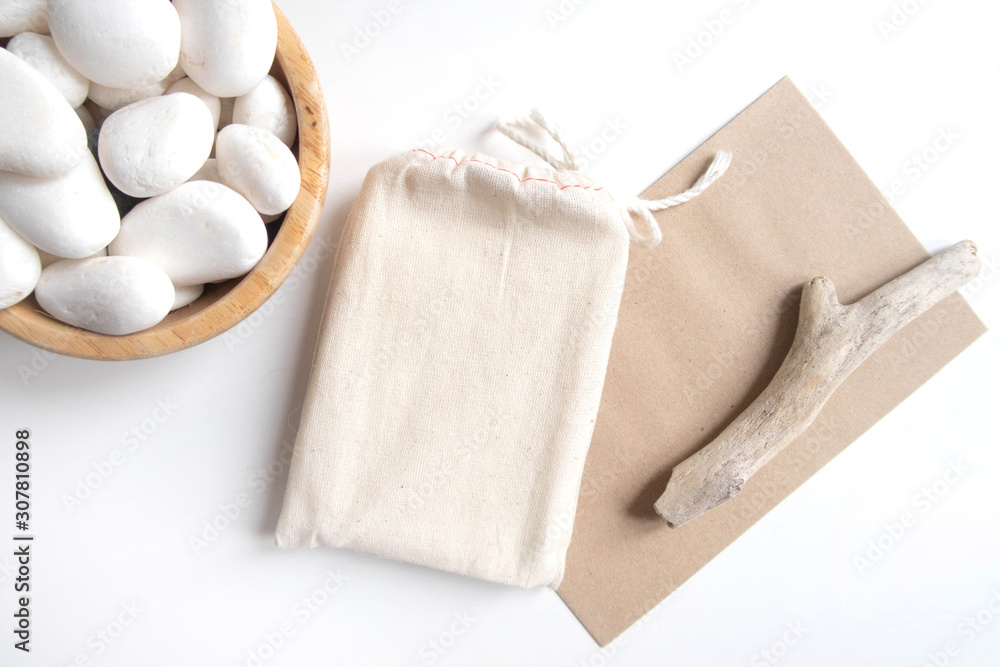 Mock up of tarot deck cotton bag with texture paper craft brown envelope and rustic stick on white background. Boho design of tarot cards pouch on white table with copy space for image or text. Mock up of tarot deck cotton bag with texture paper craft brown envelope and rustic stick on white background. Boho design of tarot cards pouch on white table with copy space for image or text.