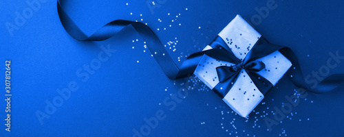 Photography Gift or present box and gold stars confetti on black table top view