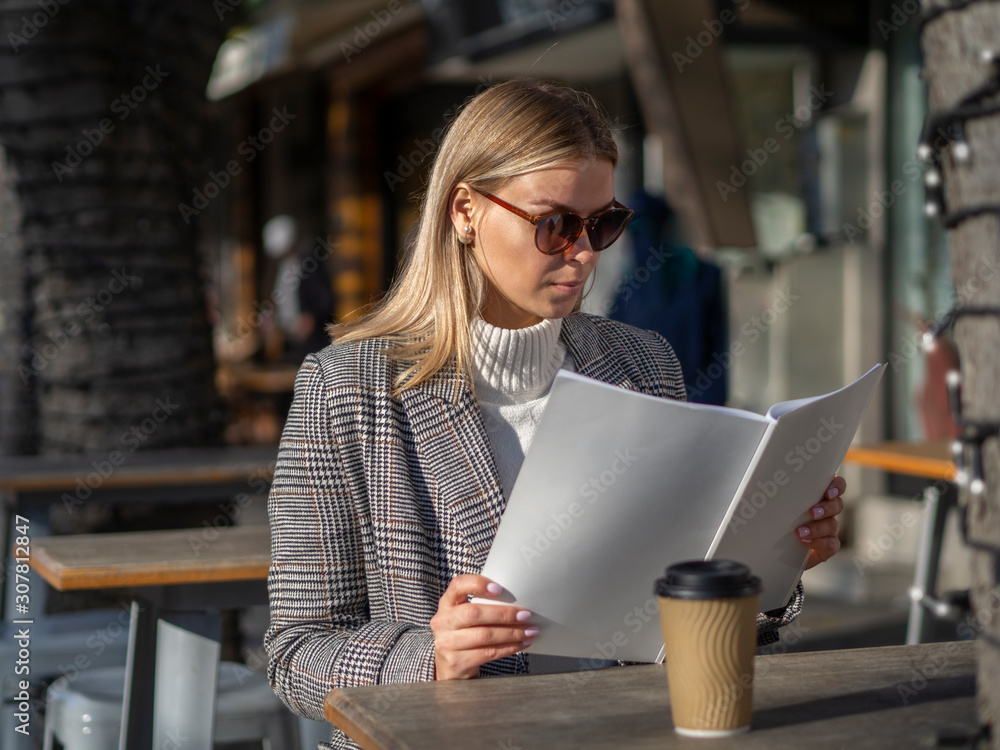 Fashion woman in sunglasses and a coat on a cold spring day