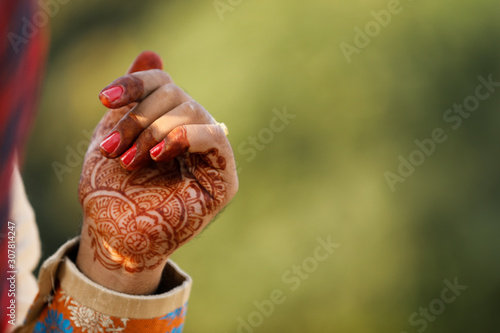 Beautiful Indian bride hand with mehandi design and jewelry 