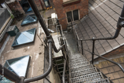 urban new york style metal vintage steel fire escape ladder stairs in manchester england. Fire escape route on the side of a building saves lives.