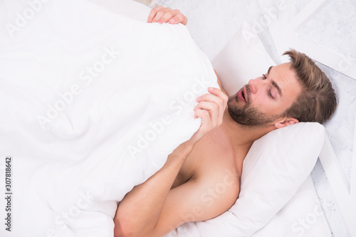 Man looking under blanket. Morning wood formally known nocturnal penile tumescence common occurrence. Male reproductive system. Why men get morning erections. Normal erections occur. Guy relax in bed