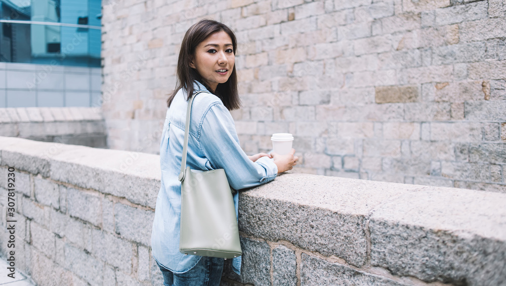 Modern Asian laidback casual woman relaxing on street Modern Asian laidback casual woman relaxing on street