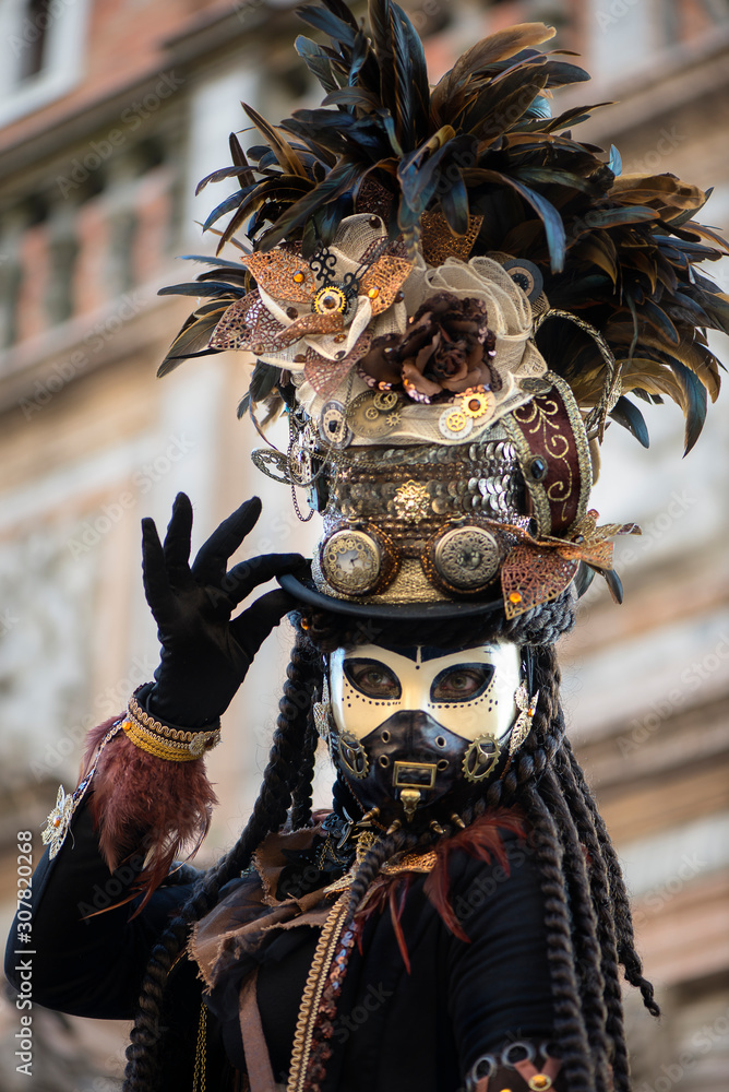 Participant of Venetian carnival in beautiful fantasy hat. Mad Hatter concept