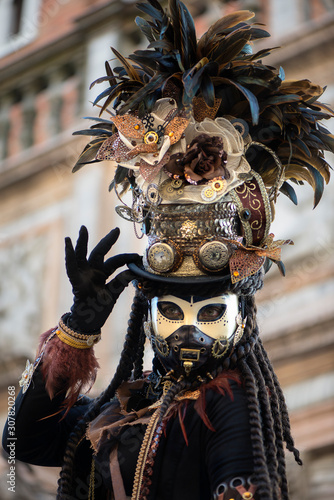 Participant of Venetian carnival in beautiful fantasy hat. Mad Hatter concept