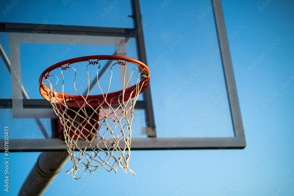 Basketball rim in a blue sky background
