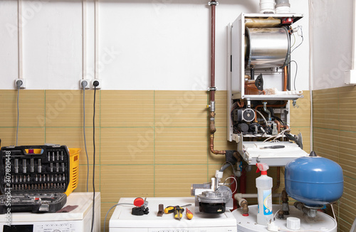 Obraz na płótnie plumber fixing central heating system, Worker servicing a gas boiler w salonie