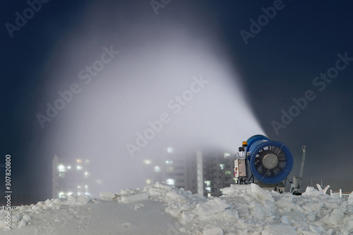 Artificial snow machine cannon making snowflakes.