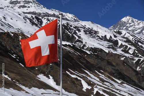 scenic view of swiss flag in front of snowcapped mountains against sky