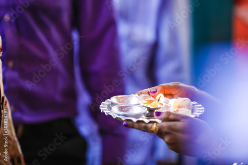 Holding puja thali and oil lamp in hand