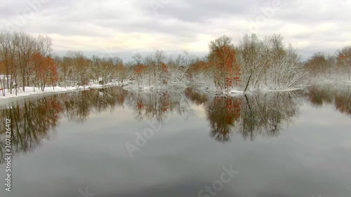 Snow coated trees beside the Peshtigo River reflected in dark November waters. photo