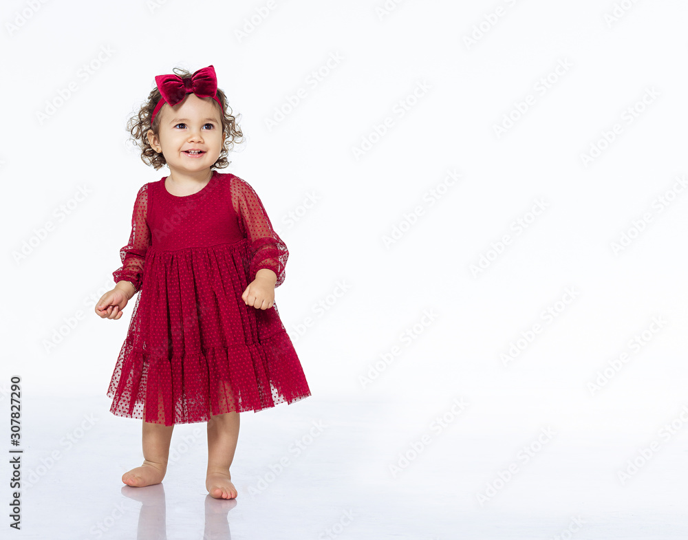 child 2 years old girl in a red dress isolate white background dancing smiling pretty beautiful in a bow festive outfit birthday new year christmas