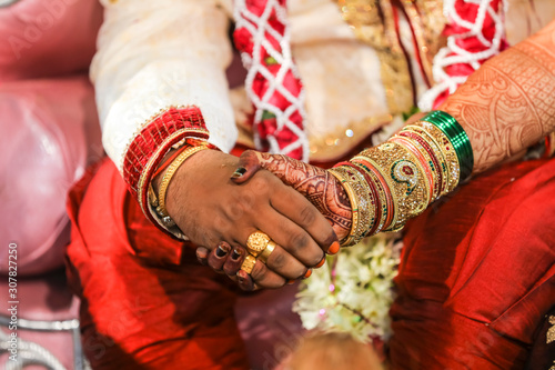 Traditional indian wedding ceremony, groom holding hand in bride hand