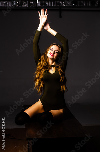 Beautiful dancer. Girl model. the girl sits in a hat and sits on a table. girl in a beautiful underwear. the girl is sitting on the table and fooling around, making faces. smooth, well-groomed legs photo