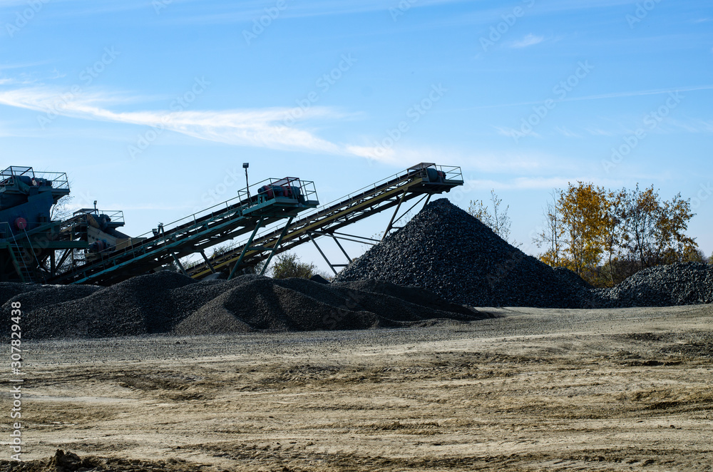 Fototapeta premium Mobile Stone crusher machine by the construction site or mining quarry for crushing old concrete slabs into gravel and subsequent cement production