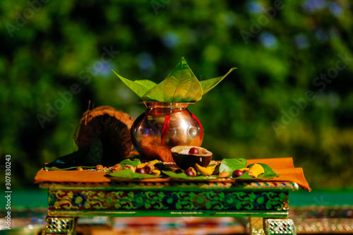 Indian wedding ceremony : decorative coper kalash with green leaf and coconut  photo