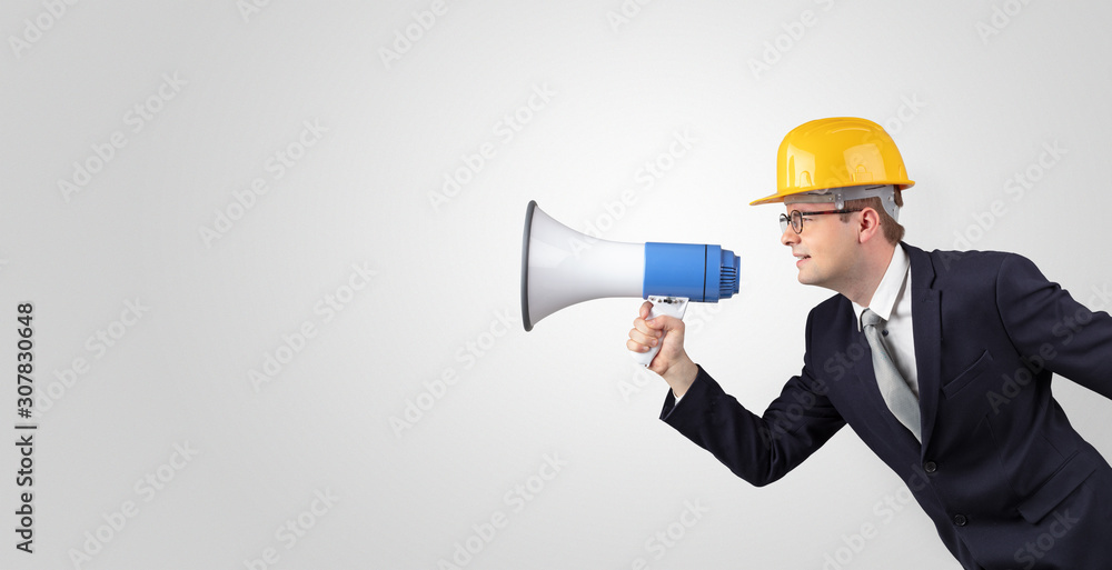 Young architect constructor yelling with megaphone and copyspace Young architect constructor yelling with megaphone and copyspace