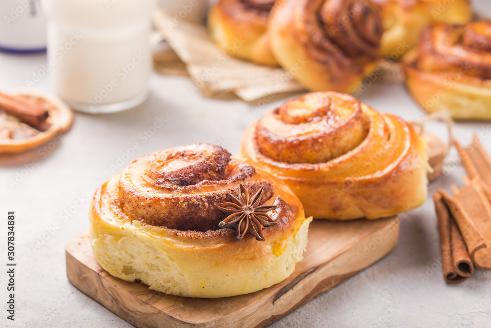 Confectionery baking. Sweet fresh soft roll bun with cinnamon on concrete background. Christmas food recipe Confectionery baking. Sweet fresh soft roll bun with cinnamon on concrete background. Christmas food recipe