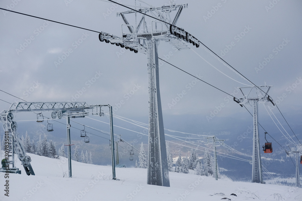 Winter landscape in Sheregesh. Funicular for tourists, skiers and snowboarders. lift to transport people in the mountains. the cable car on the background of blue mountains. funicular in the mountains Winter landscape in Sheregesh. Funicular for tourists, skiers and snowboarders. lift to transport people in the mountains. the cable car on the background of blue mountains. funicular in the mountains