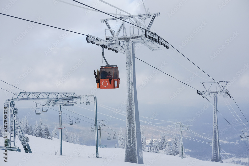 Winter landscape in Sheregesh. Funicular for tourists, skiers and snowboarders. lift to transport people in the mountains. the cable car on the background of blue mountains. funicular in the mountains Winter landscape in Sheregesh. Funicular for tourists, skiers and snowboarders. lift to transport people in the mountains. the cable car on the background of blue mountains. funicular in the mountains