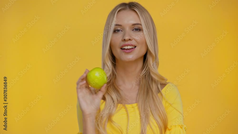 smiling woman holding apple isolated in yellow smiling woman holding apple isolated in yellow