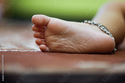 Fotografie Anklets in little child girl leg