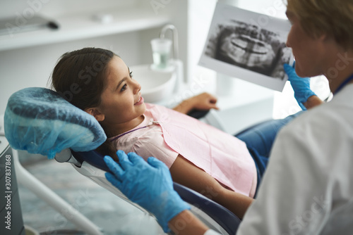 Professional female dentist holding a dental scan
