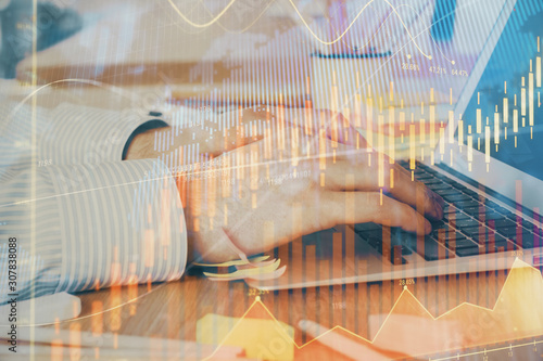 Multi exposure of stock market graph with man working on laptop on background. Concept of financial analysis.