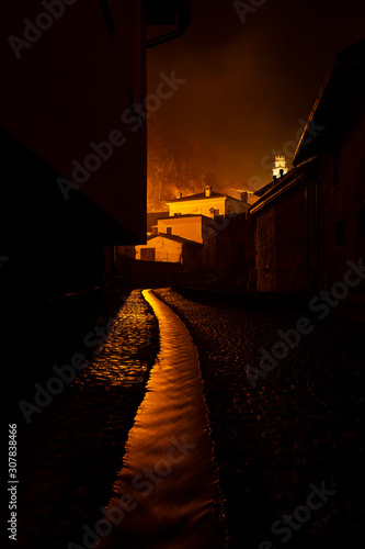 Polcenigo at night, a small medieval village in Friuli Venezia Giulia, Italy.  Small canalization of and old mill from  Gorgazzo river. photo