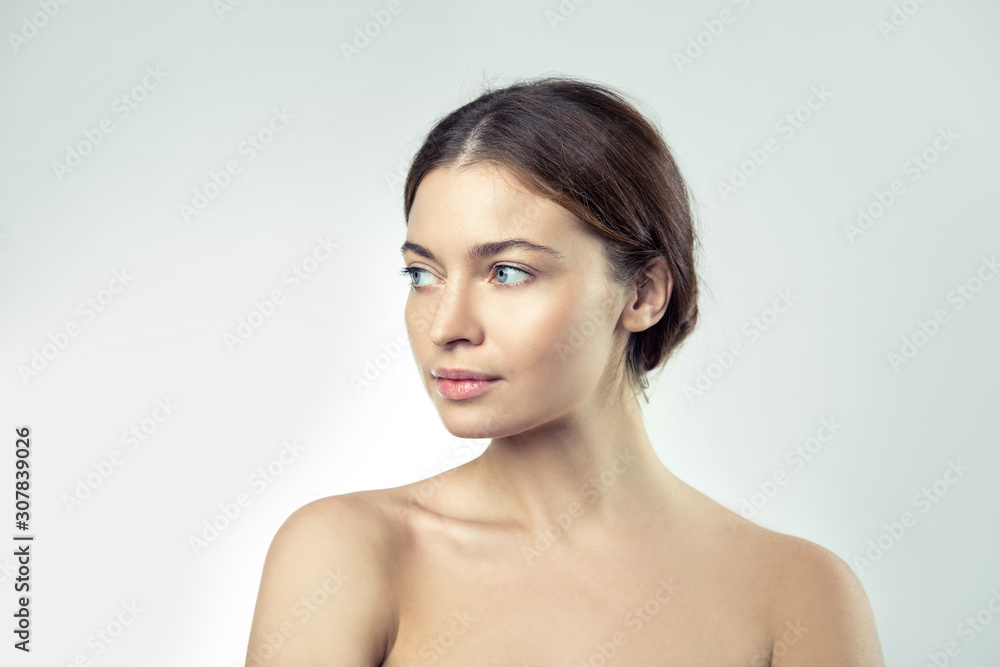 Young beautiful woman with bare shoulders, beauty portrait on a light background. Young beautiful woman with bare shoulders, beauty portrait on a light background.