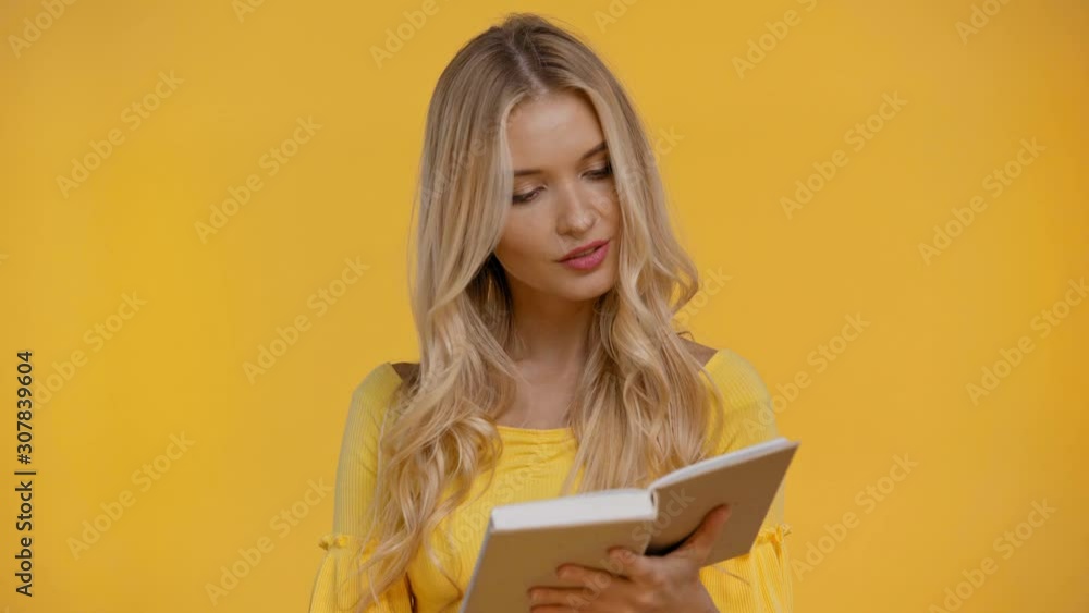 woman reading book and smiling isolated in yellow woman reading book and smiling isolated in yellow