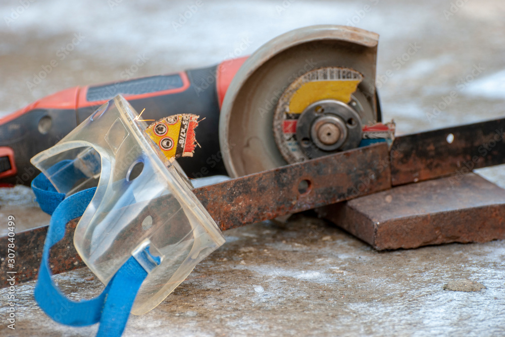 An element of a detachable abrasive disk stuck in goggles while working with a catch grinder